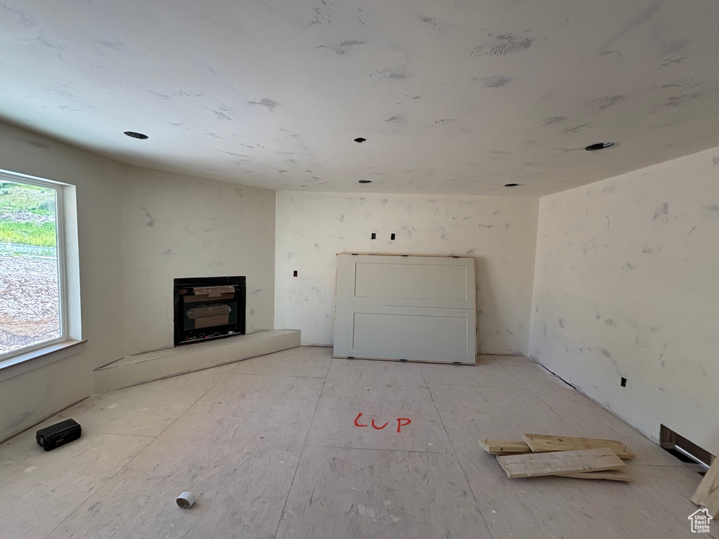 Unfurnished living room with a fireplace with raised hearth