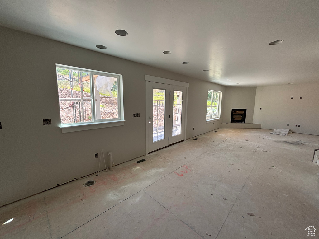 Unfurnished living room featuring a fireplace with raised hearth and recessed lighting