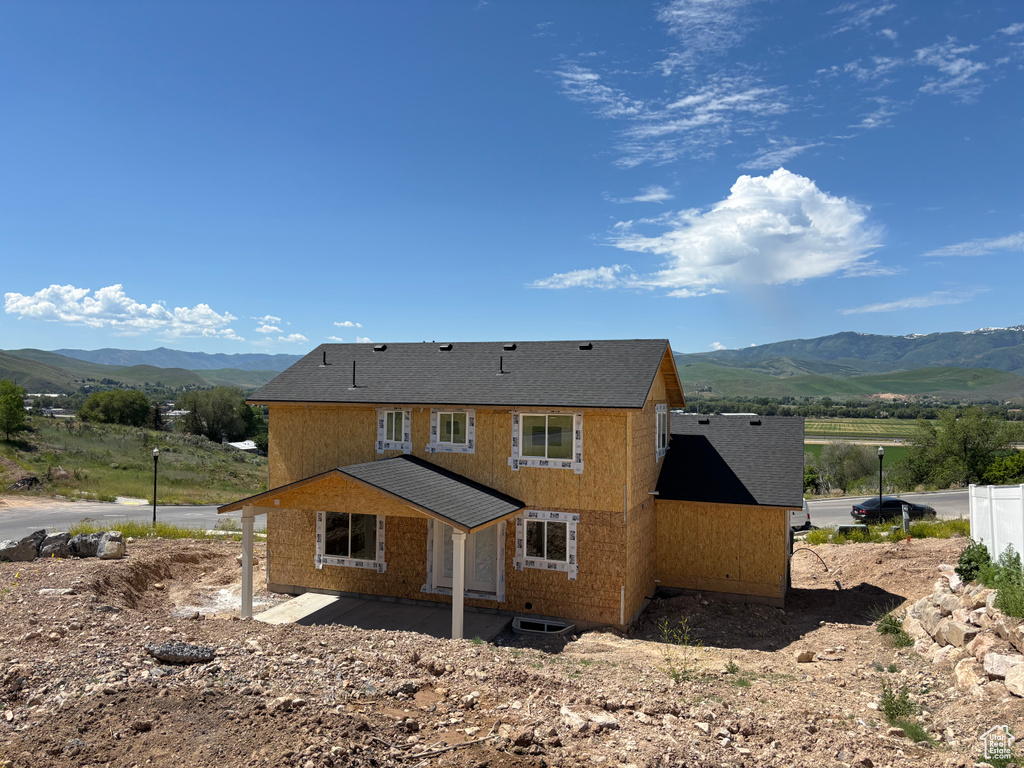 Rear view of house featuring a mountain view and a patio area