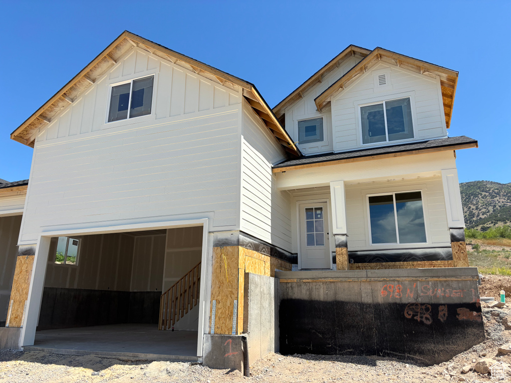 View of front of property featuring a garage, board and batten siding, and a mountain view