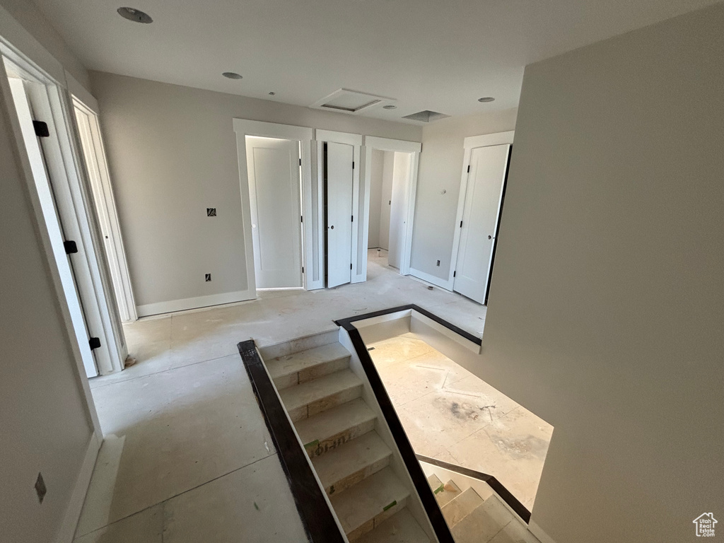 Unfurnished bedroom featuring baseboards and attic access