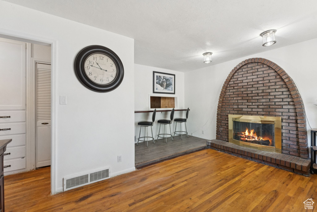 Unfurnished living room with wood finished floors, a fireplace, and baseboards