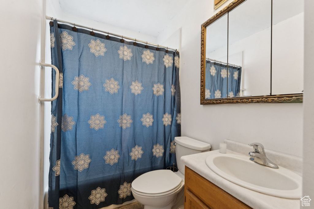 Bathroom featuring vanity, toilet, and a shower with shower curtain