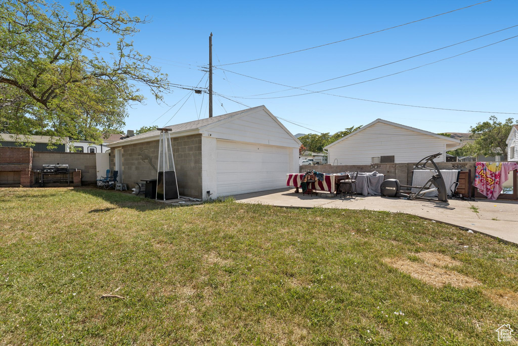 View of yard featuring a garage and an outbuilding