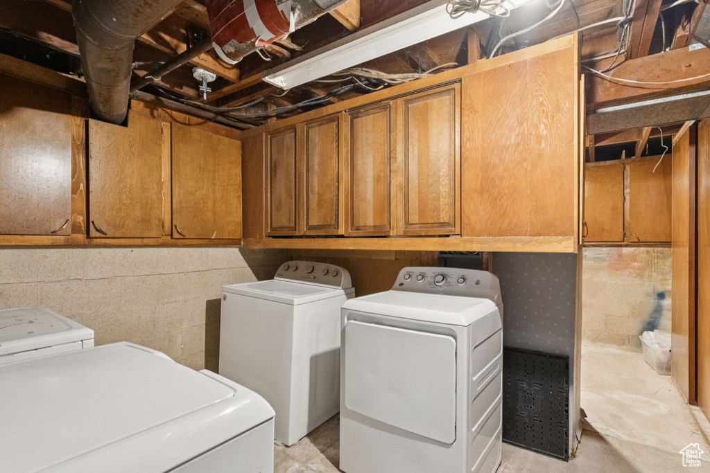 Washroom featuring washing machine and dryer and cabinet space