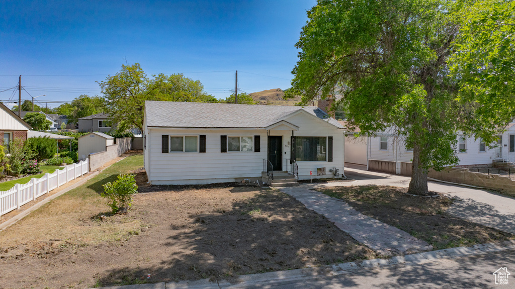 View of front of home with entry steps and a shingled roof