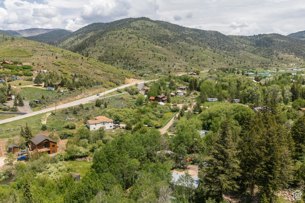 Aerial view of property and surrounding area featuring a mountainous background