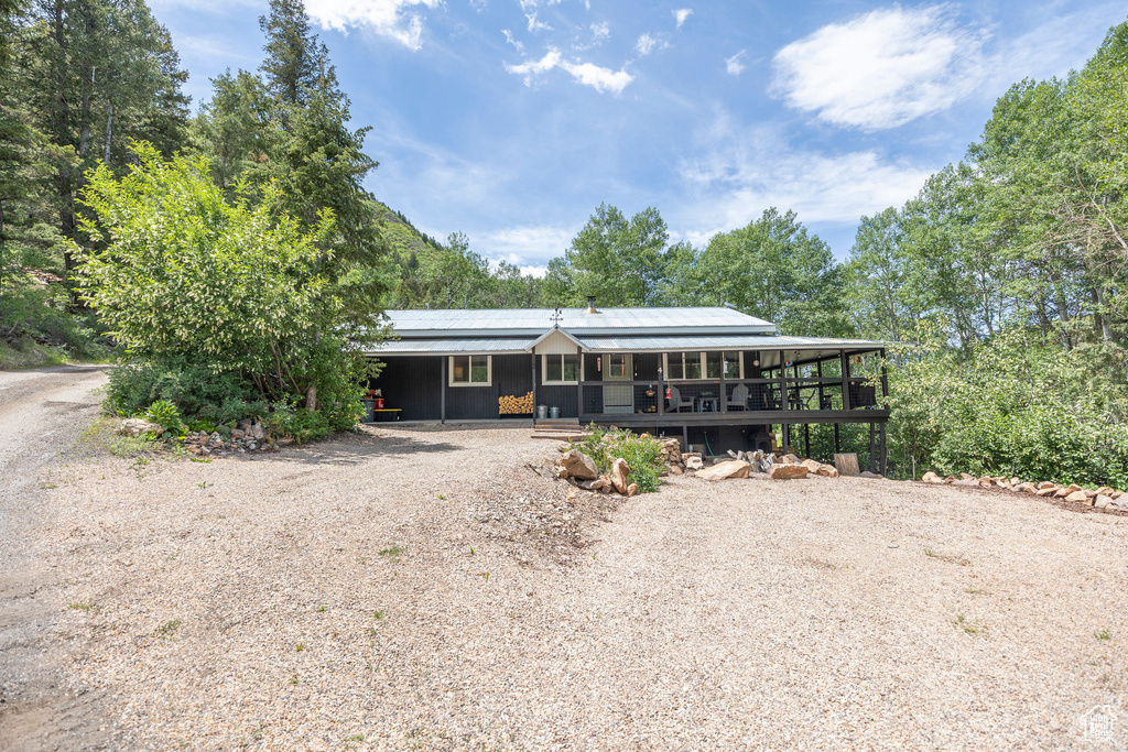 View of front facade featuring gravel driveway and covered porch