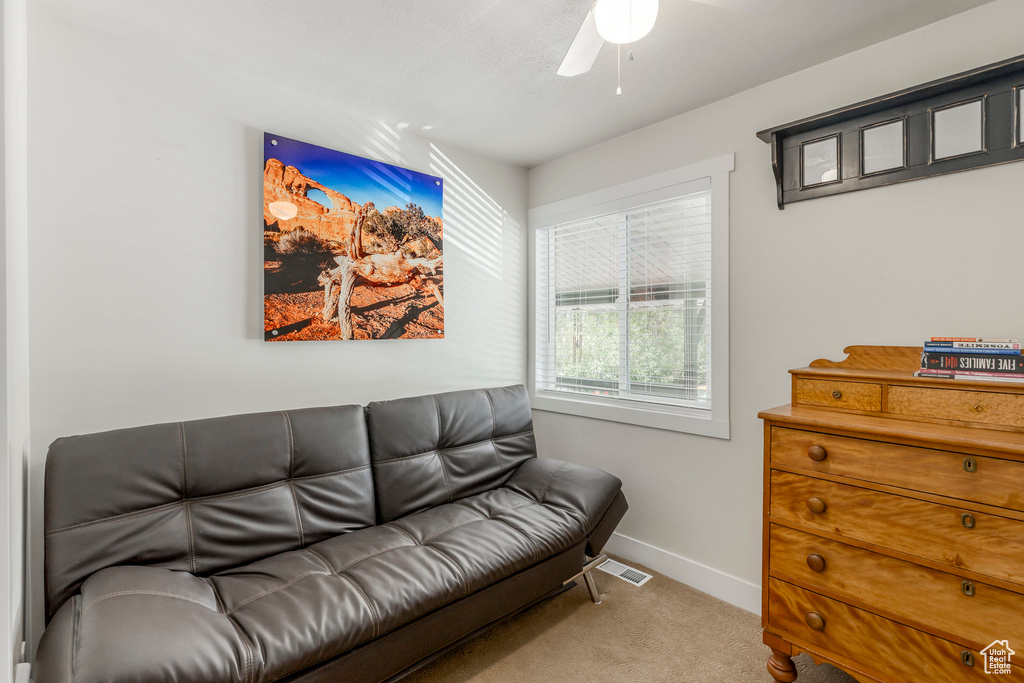 Carpeted living room with baseboards and a ceiling fan