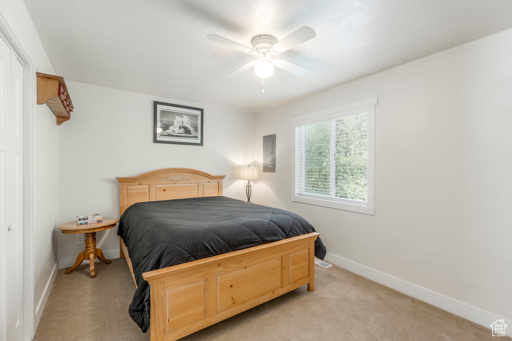 Bedroom with baseboards, light colored carpet, and a ceiling fan