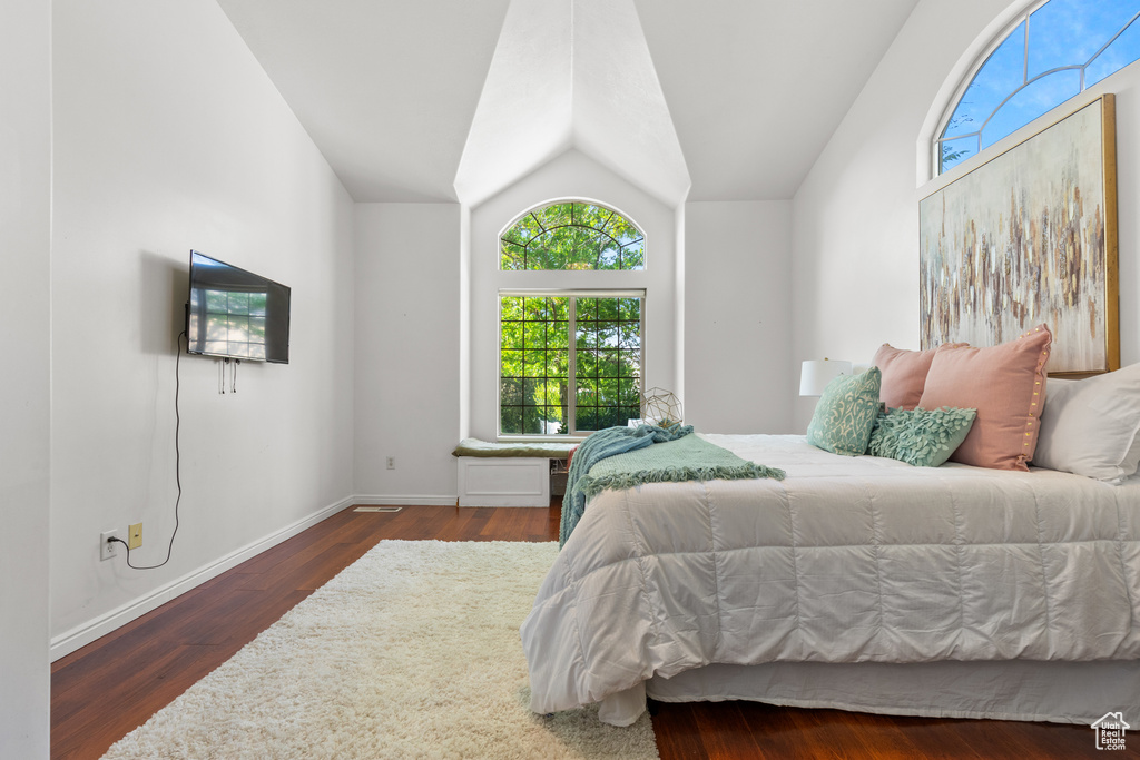 Bedroom featuring lofted ceiling, wood finished floors, and baseboards