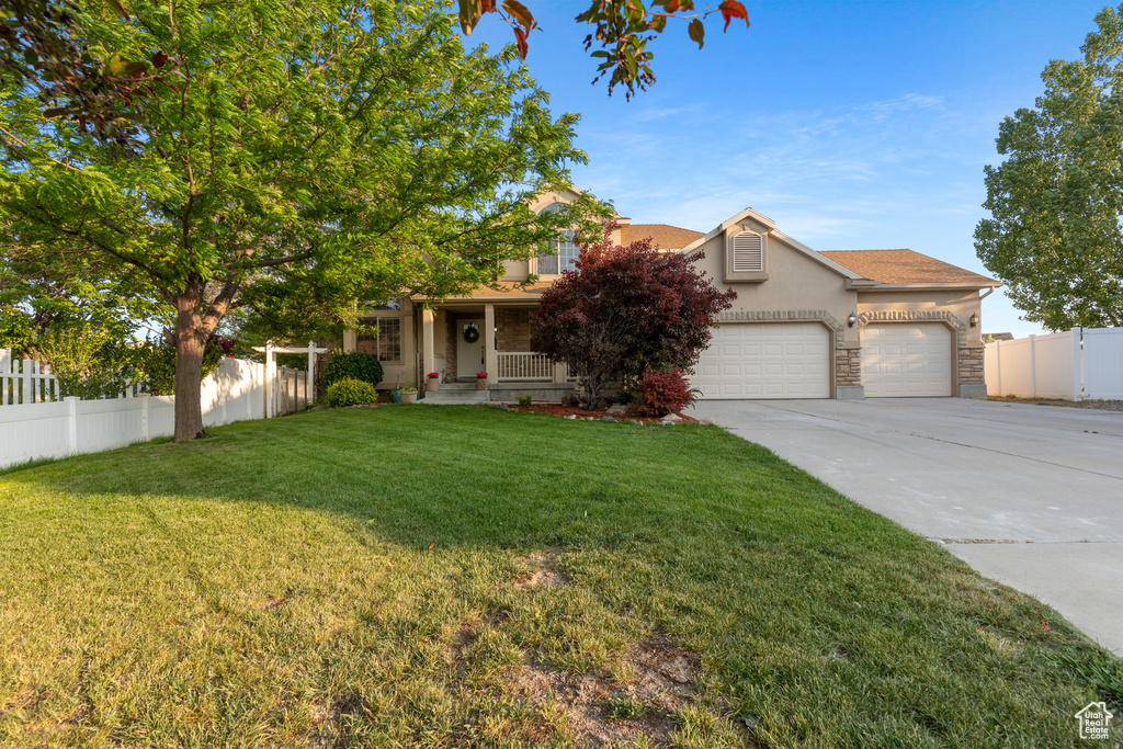 Obstructed view of property with stucco siding, driveway, a garage, a porch, and stone siding