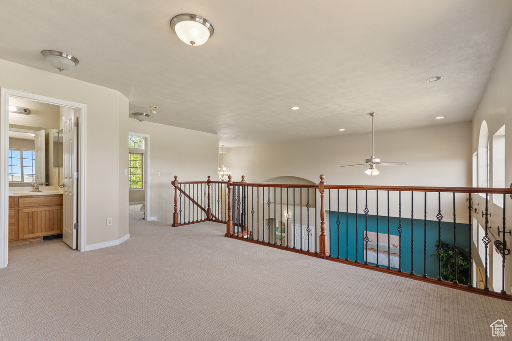 Hall featuring recessed lighting, light carpet, baseboards, and an upstairs landing