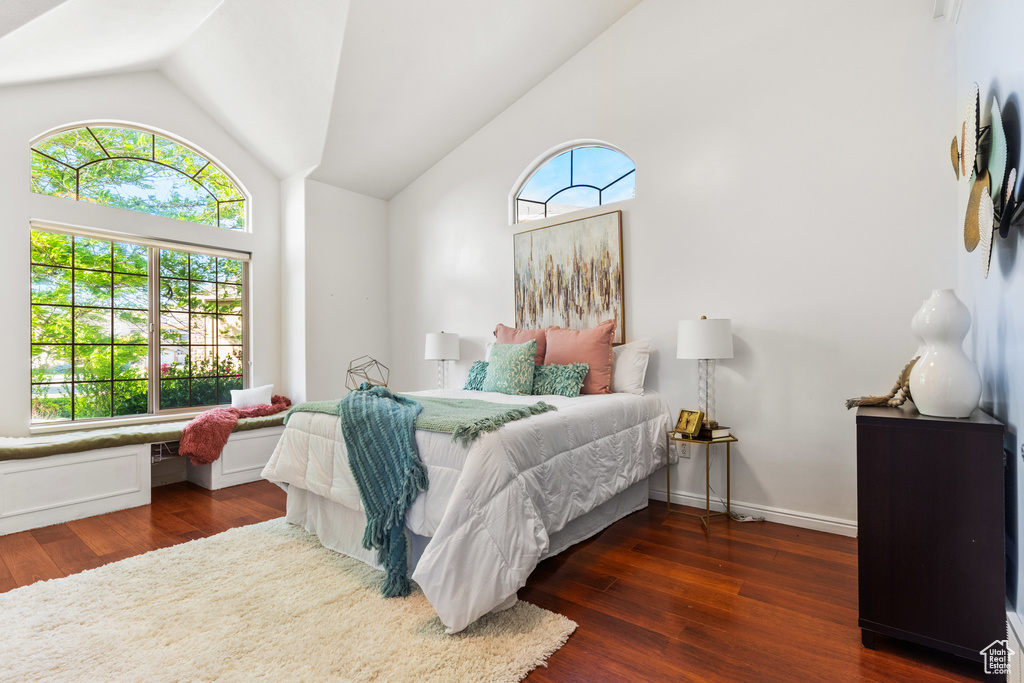 Bedroom with lofted ceiling and wood finished floors