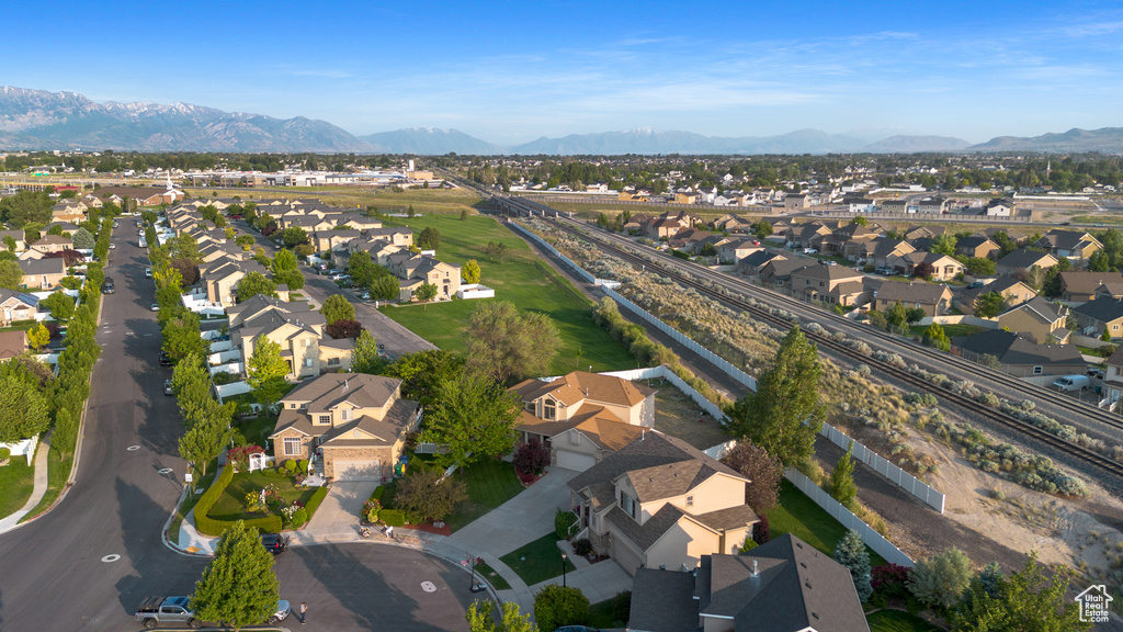 Aerial view of property and surrounding area with nearby suburban area and a mountain backdrop