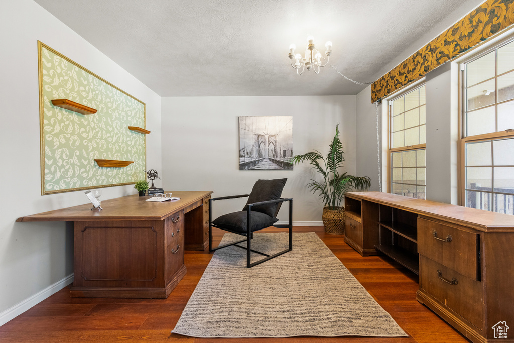 Home office with a chandelier, baseboards, and dark wood-type flooring