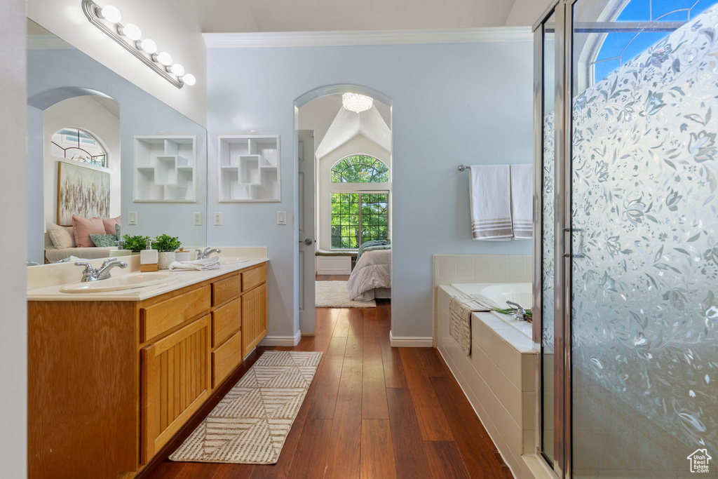 Bathroom with a bath, ensuite bath, double vanity, hardwood / wood-style flooring, and a stall shower