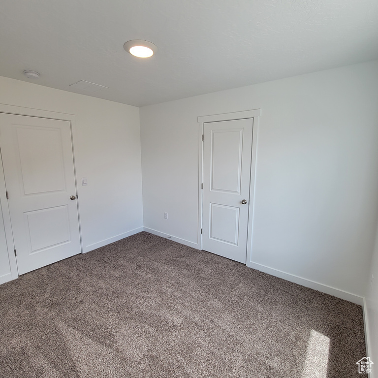 Unfurnished room with carpet flooring, a smoke detector, and baseboards