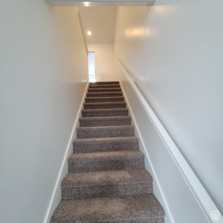 Stairs with carpet and recessed lighting
