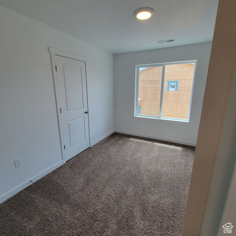 Carpeted empty room with baseboards