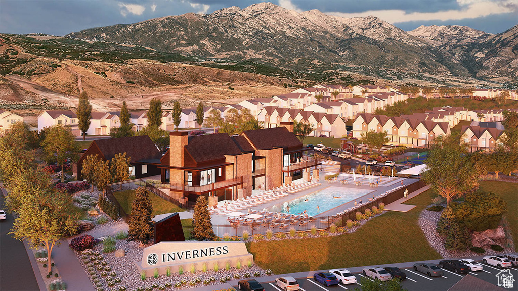 Aerial perspective of suburban area featuring a mountainous background and a pool area