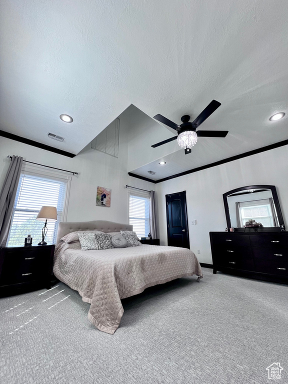 Carpeted bedroom with a textured ceiling, multiple windows, ceiling fan, recessed lighting, and ornamental molding