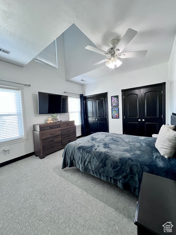 Carpeted bedroom with multiple windows, baseboards, and ceiling fan