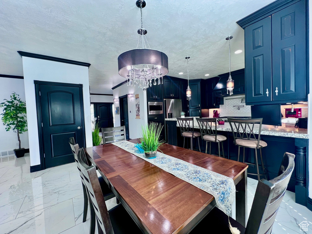 Dining space with light marble finish floors, recessed lighting, a chandelier, baseboards, and a textured ceiling