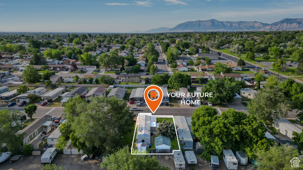 Aerial perspective of suburban area featuring property boundaries highlighted and a mountain backdrop