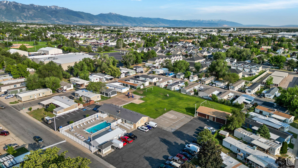 View of property location featuring a mountainous background, a pool, and nearby suburban area
