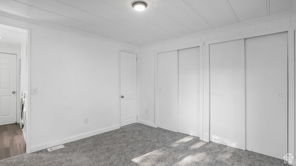 Unfurnished bedroom with multiple closets, carpet floors, and ornamental molding