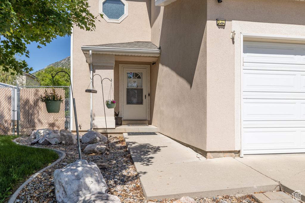Property entrance with stucco siding and an attached garage