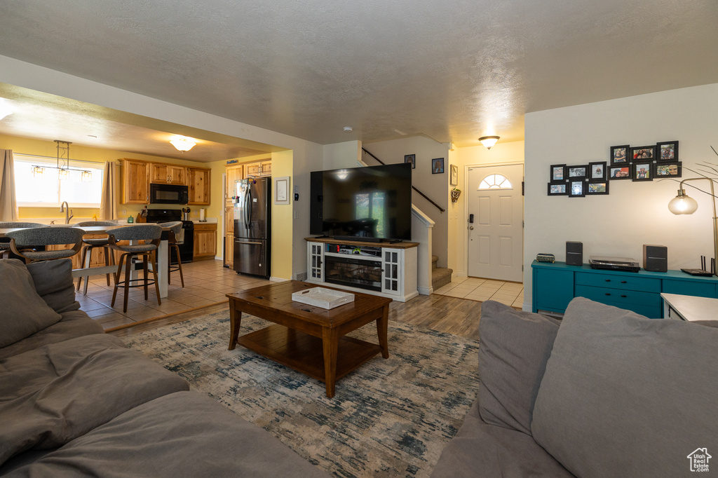 Living area with stairway and light tile patterned floors