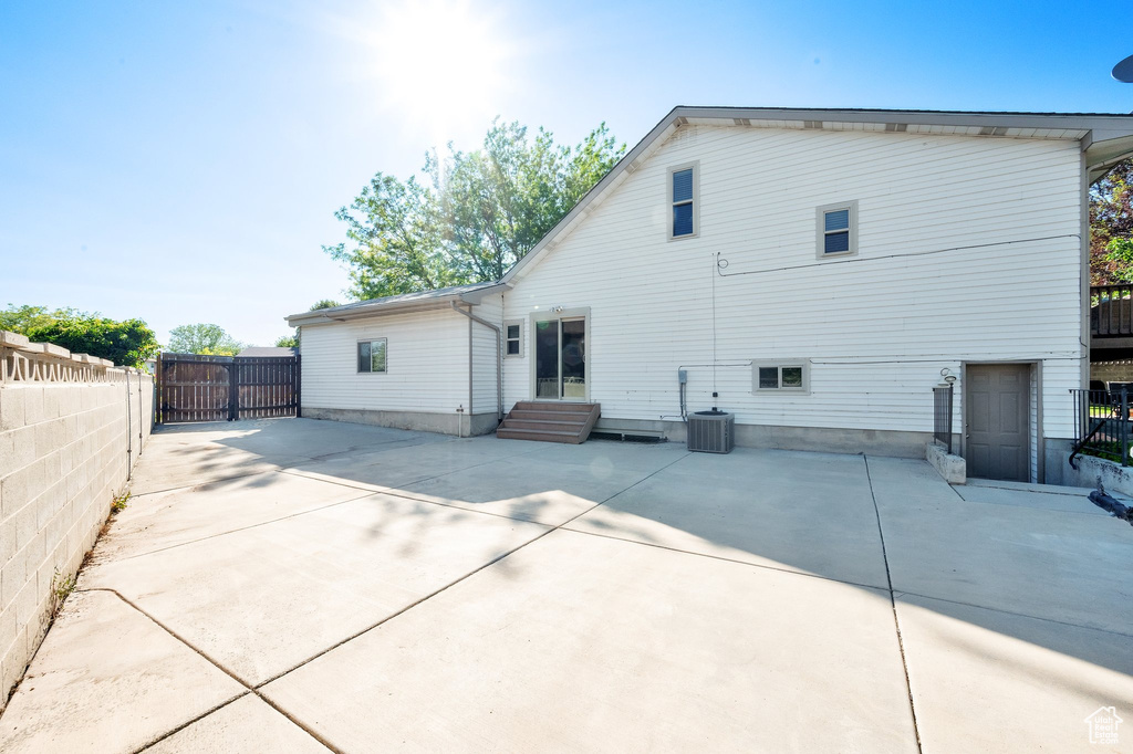 Rear view of house featuring a patio, a gate, and central air condition unit