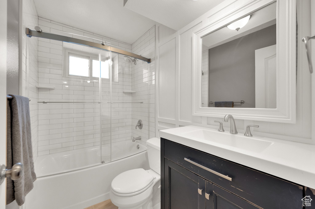 Full bath with toilet, vanity, and enclosed tub / shower combo