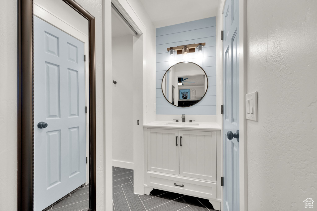 Bathroom featuring vanity, a ceiling fan, and a textured wall