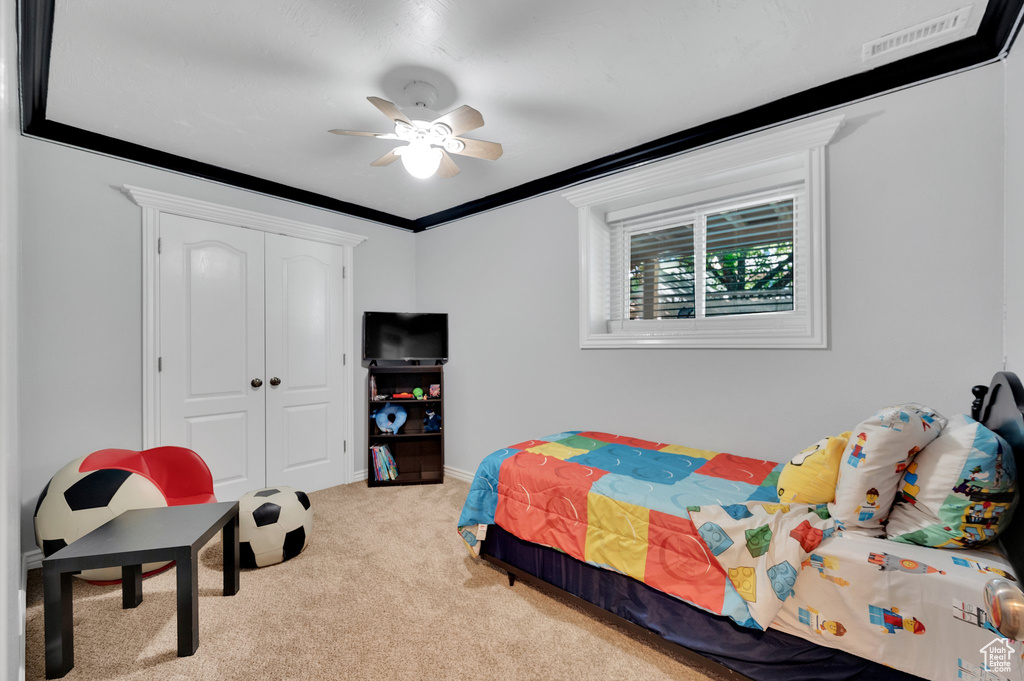 Bedroom featuring light colored carpet, a closet, a ceiling fan, and baseboards