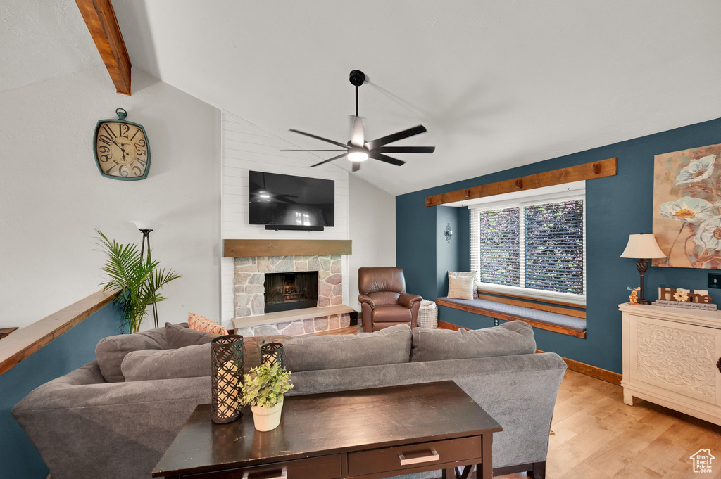 Living room with ceiling fan, light wood-type flooring, and a fireplace