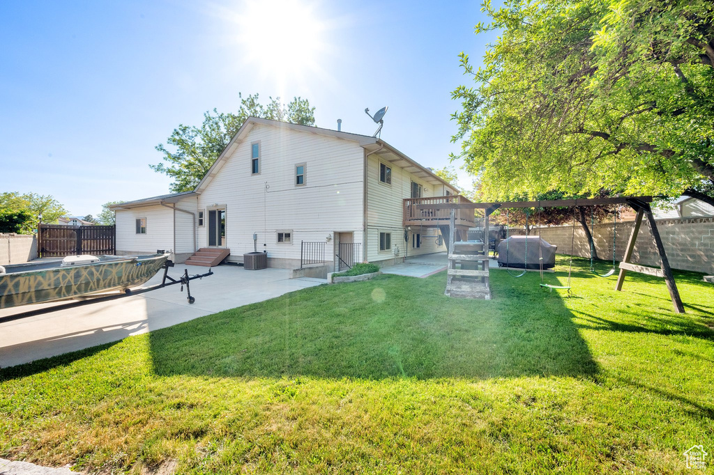 Back of property with a patio area, a deck, and central AC unit