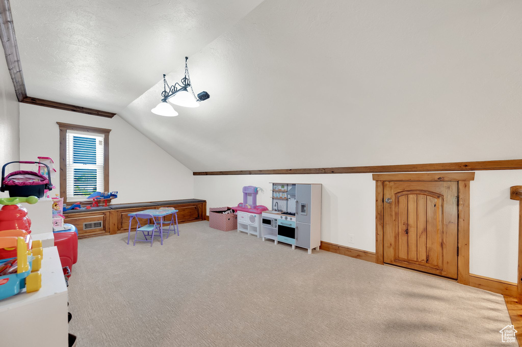 Playroom with vaulted ceiling, carpet flooring, and baseboards