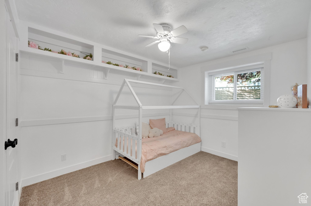 Carpeted bedroom with baseboards and a ceiling fan