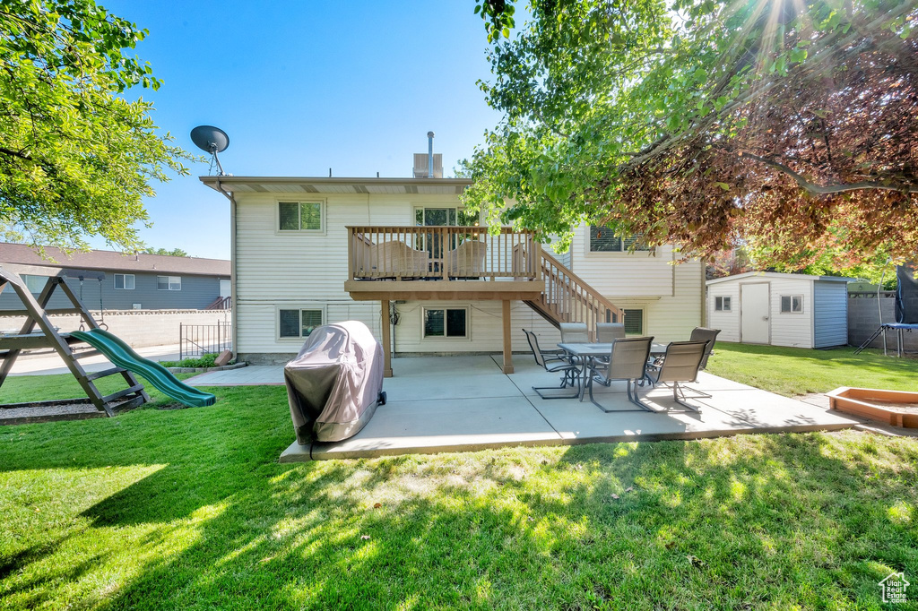 Back of property featuring a patio area, a playground, and a deck