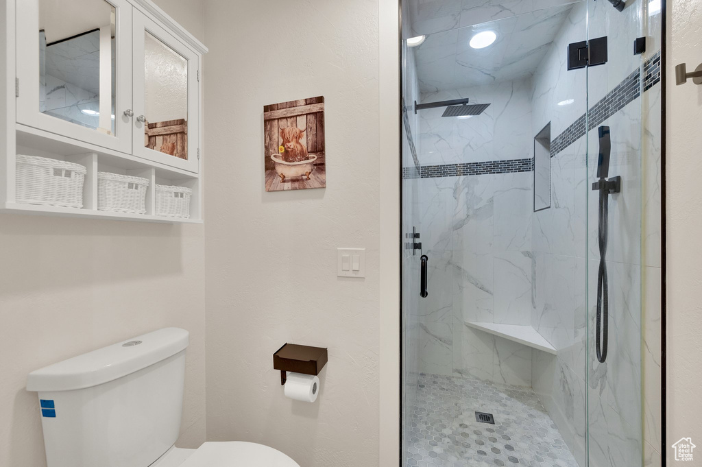 Bathroom with a marble finish shower and toilet