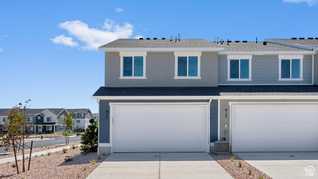 View of front of house featuring concrete driveway, an attached garage, a residential view, and roof with shingles