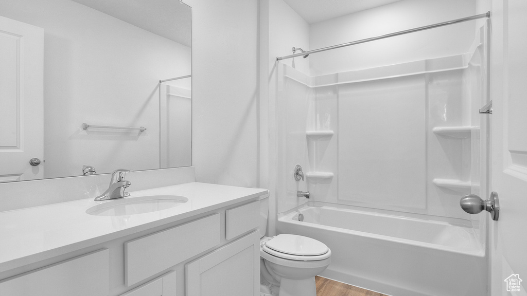 Bathroom featuring vanity, shower / washtub combination, toilet, and wood finished floors