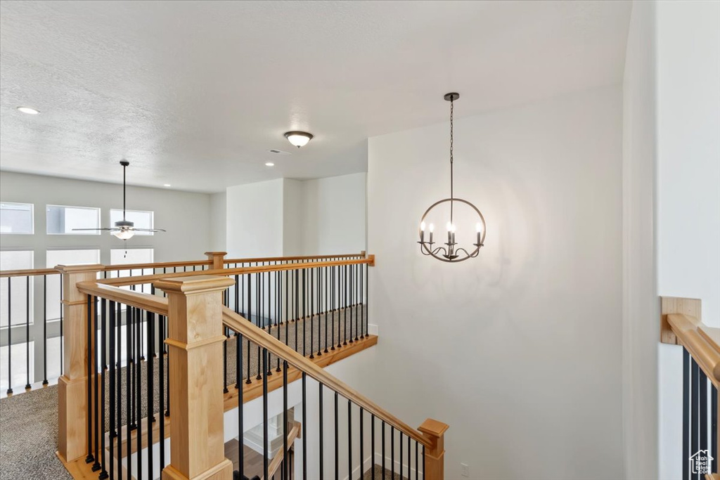 Corridor with an upstairs landing, a chandelier, and recessed lighting