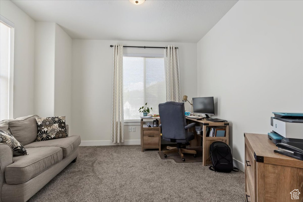 Carpeted home office featuring baseboards