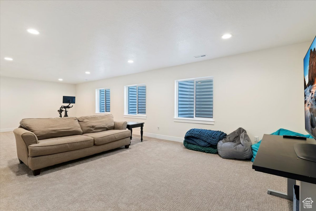 Carpeted living area with recessed lighting and baseboards