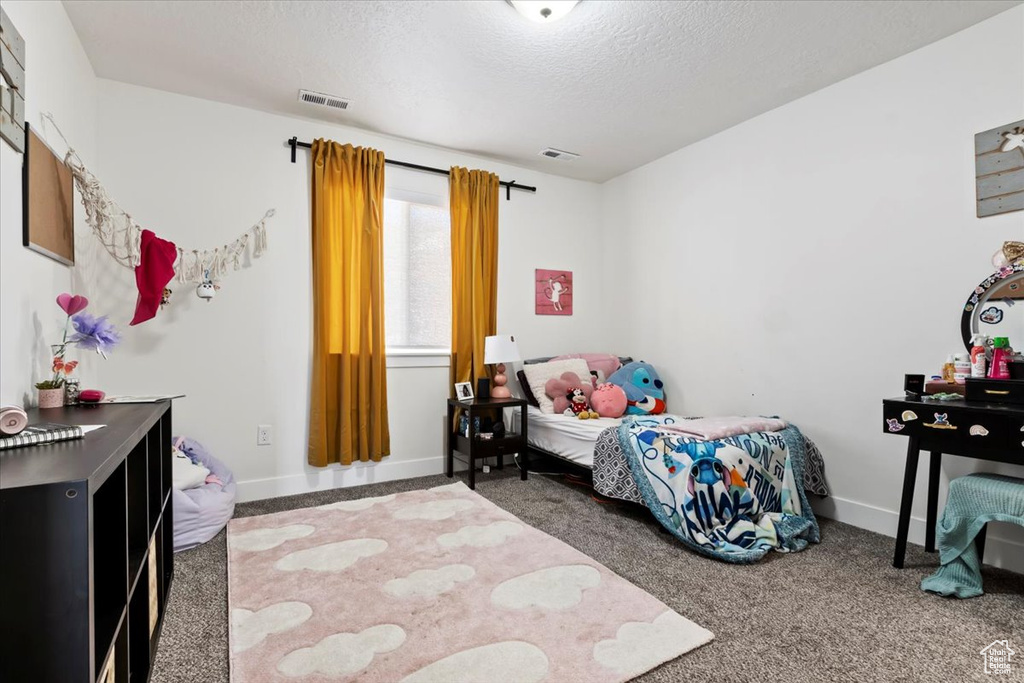Bedroom featuring carpet flooring, a textured ceiling, and baseboards