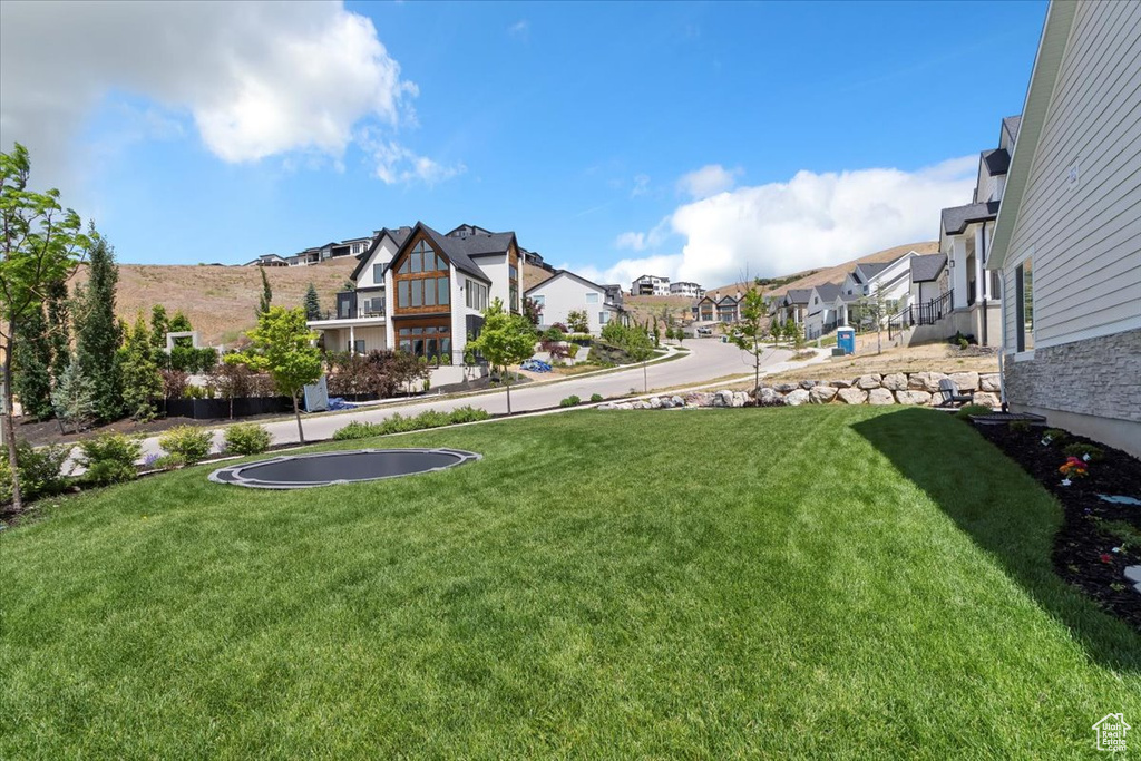 View of green lawn with a residential view